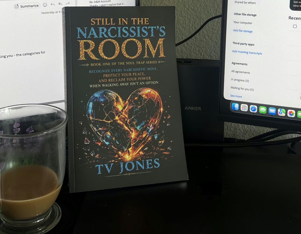 Still In The Narcissist’s Room on a reader’s desk beside a cup of coffee